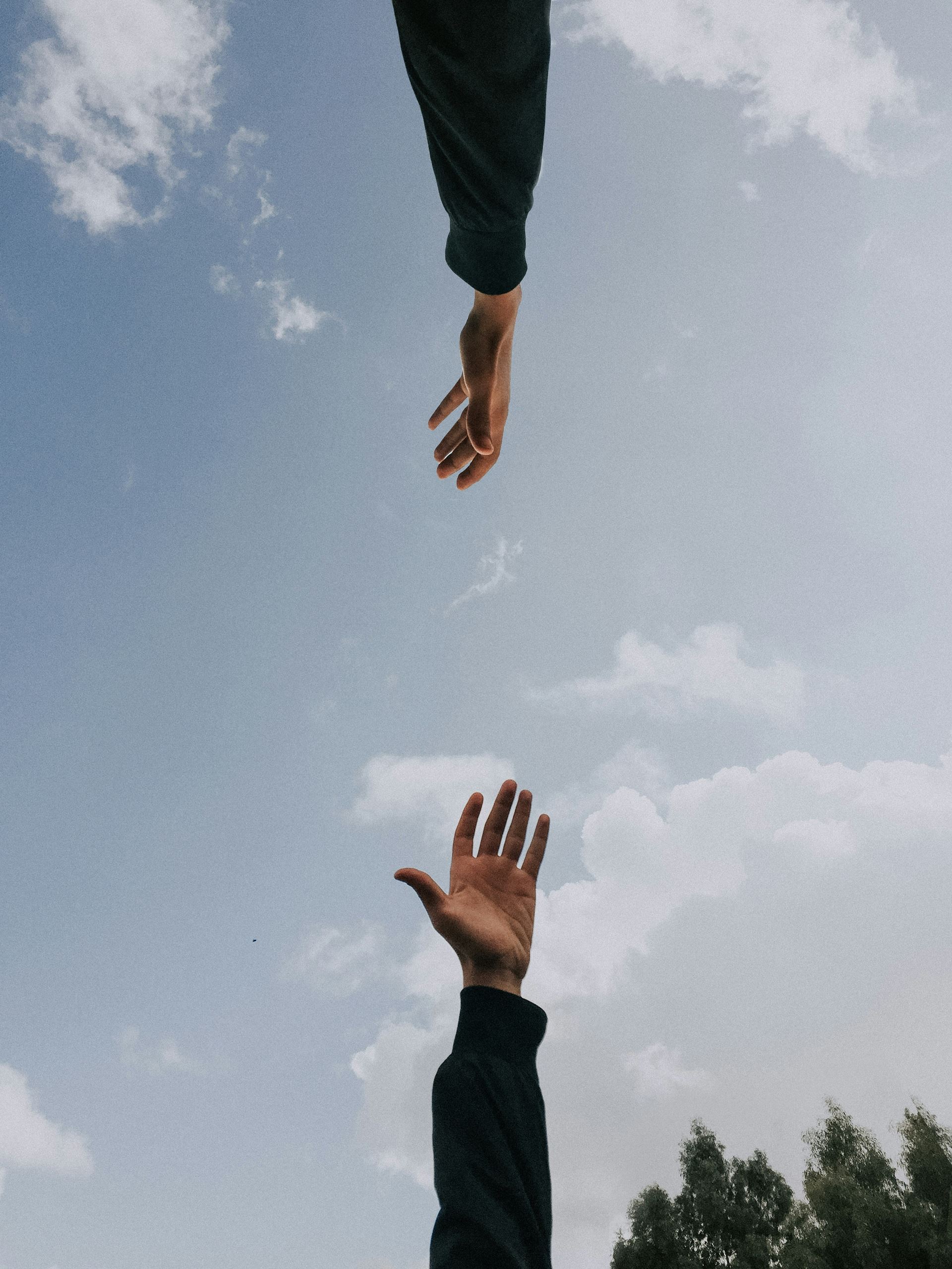 two hands separated by blue sky